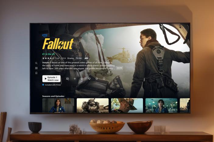 TV mounted on a wall, showing Amazon Prime TV's new layout. Screen shows details for Fallout.