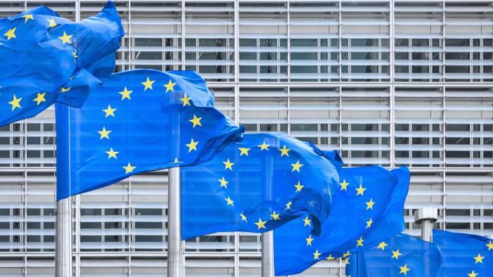 European Union Flag EU Flags side by side in the Wind- European Union Flags in a row in front of the facade of the European Commission Headquarter blowing in the wind. European Commission, Downtown Brussels, Belgium, Europe