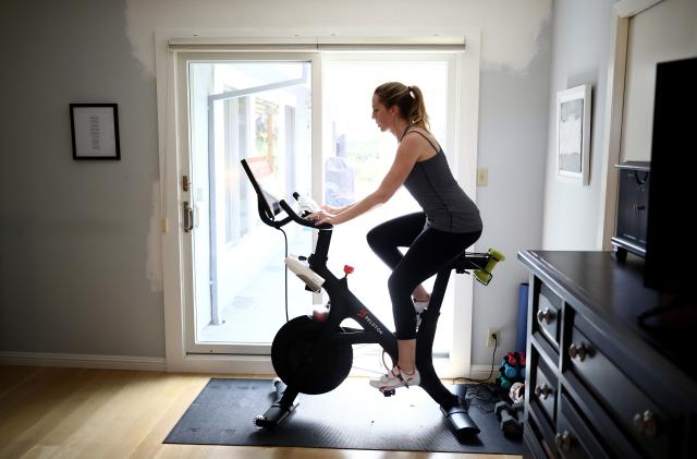 SAN ANSELMO, CALIFORNIA - APRIL 07:  Jen Van Santvoord rides her Peloton exercise bike at her home on April 07, 2020 in San Anselmo, California.  More people are turning to Peloton due shelter-in-place orders because of the coronavirus (COVID-19). The Peloton stock has continued to rise over recent weeks even as most of the stock market has plummeted. Peloton announced yesterday that they will temporarily pause all live classes until the end of April because an employee tested positive for COVID-19.  (Photo by Ezra Shaw/Getty Images)