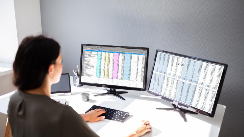 Side View Of Businesswoman's Hand Analyzing Data On Computer Over Desk