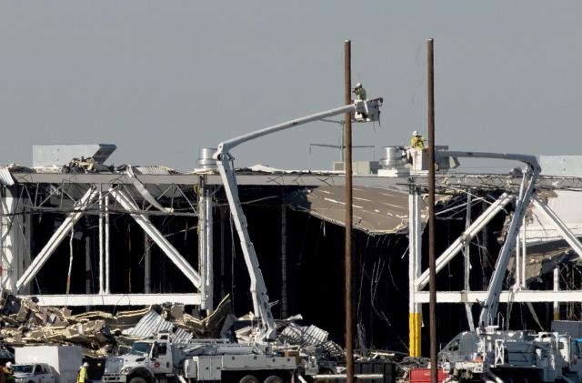 Amazon crew on lifts document the damage from the tornado that hit an Amazon distribution centre where the roof collapsed in Edwardsville, Illinois, U.S. December 13, 2021.  REUTERS/Lawrence Bryant