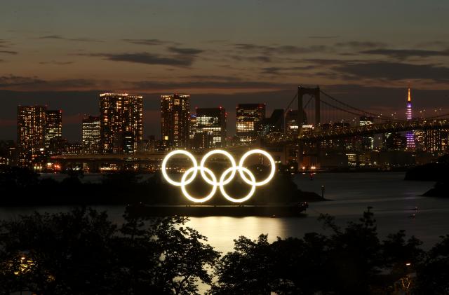 A general view of the Olympic Rings installed on a floating platform with the Rainbow Bridge in the background in preparation for the Tokyo 2020 Olympic Games in Tokyo, Japan June 21, 2021. Picture taken with long exposure.  REUTERS/Pawel Kopczynski