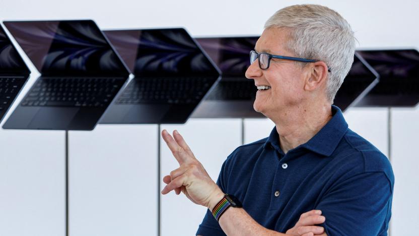 Apple CEO Tim Cook poses in front of a new MacBook Airs running M2 chips display during Apple's annual Worldwide Developers Conference in San Jose, California, U.S. June 6, 2022. REUTERS/Peter DaSilva