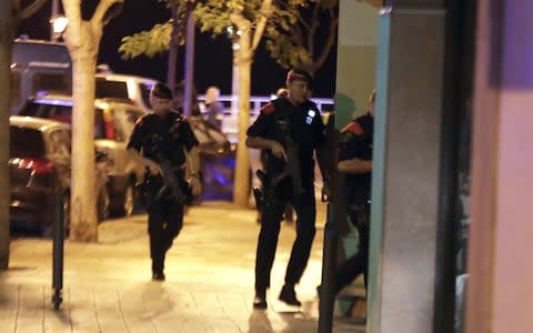Spanish Policemen inspect a street in Cambrils  - Credit: EPA