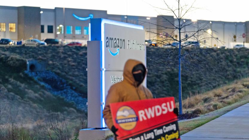 A worker pickets out front of an Amazon Fulfillment center.