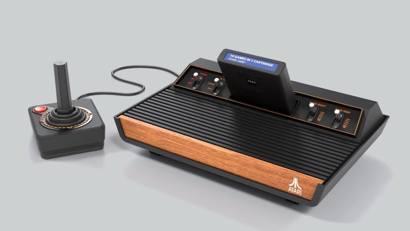 Marketing photo of a new Atari retro console (2600+) that faithfully recreates the look of the original. Vintage-looking console with front wood panel, switches and a companion joystick.