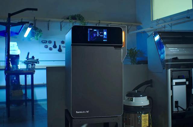 The new Formlabs SLS 3D printer is shown in a work enivironment.