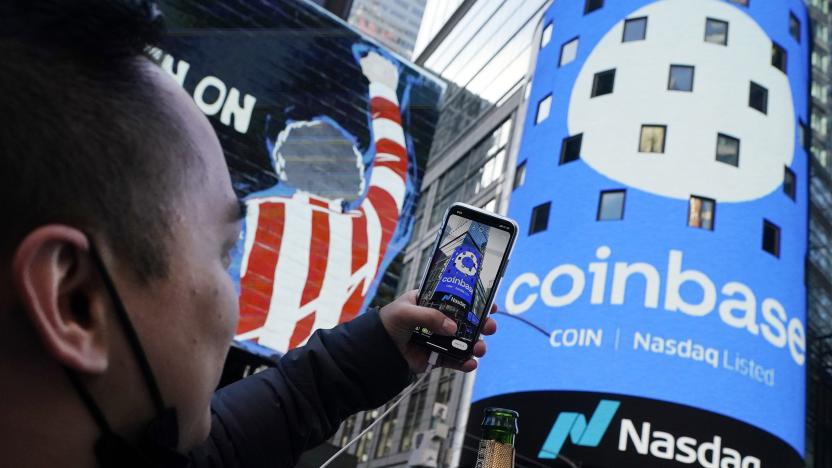 FILE - Coinbase employee Daniel Huynh holds a celebratory bottle of champagne as he photographs outside the Nasdaq MarketSite, in New York's Times Square, April 14, 2021. Coinbase rose, Friday, June 23, 2023, after winning a Supreme Court case. The crypto trading platform wanted to keep a dispute with a customer in arbitration, a process that many companies prefer over lawsuits in courts. (AP Photo/Richard Drew, File)