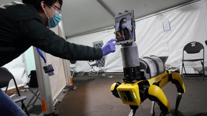 BOSTON, MA - APRIL 23: Research Scientist Hen-Wei Huang, left, talks about Spot the Robot, during a demonstration at Brigham And Women's Hospital in Boston on April 22, 2020. The demonstration featured a new mobile telemedicine platform, Spot the Robot, designed in collaboration with Brigham researchers. Spot, a Boston Dynamics robot, reduces health care worker exposure to potential Covid-19 patients and helps conserve the use of PPE. The demonstration included the robots iPad feature which visually links a patient looking at the robot with a clinician who may be steps away for easy and safe communication. Spot the Robot is currently in clinical use in the Brighams Emergency Department. (Photo by Craig F. Walker/The Boston Globe via Getty Images)