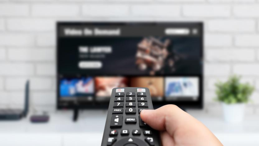 Man watching TV, remote control in hand. VOD service on TV