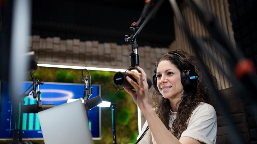 Woman with headphones and microphone indoors.