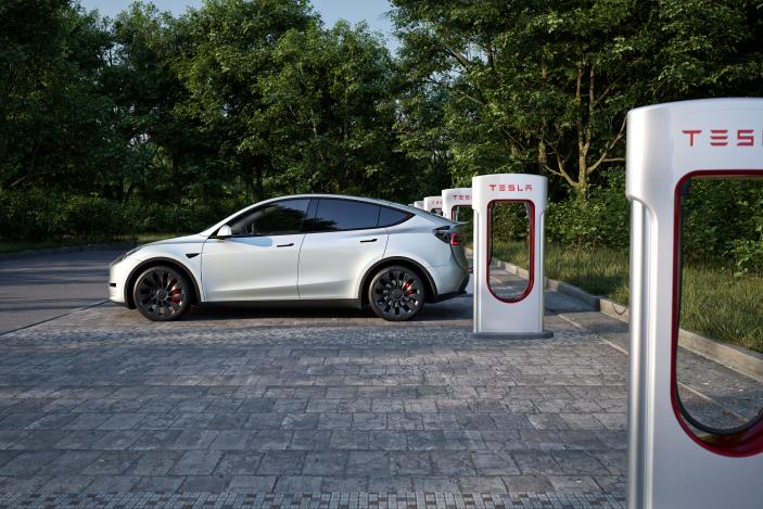 A Tesla car charges at a Supercharger station.