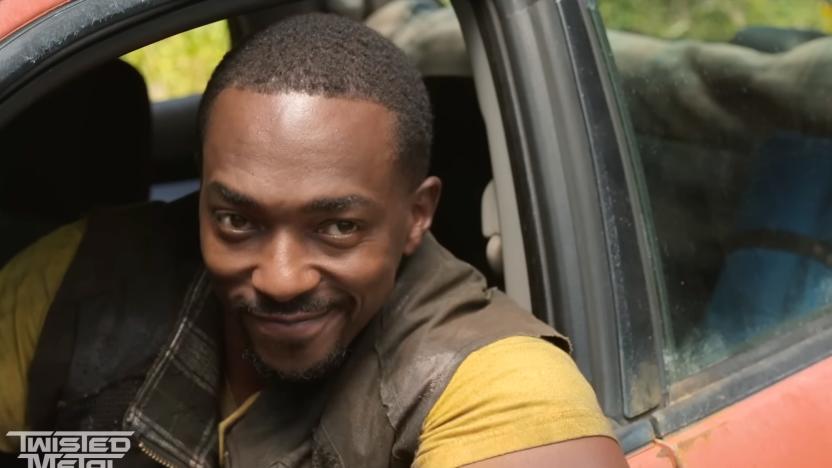 Anthony Mackie as John Doe in the trailer for Peacock’s ‘Twisted Metal’ series. He sits in the driver’s seat of a car, looking outward with a wry grin.