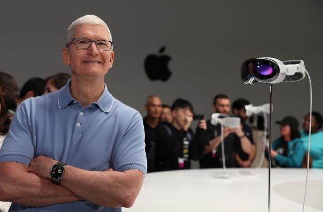 CUPERTINO, CALIFORNIA - JUNE 05: Apple CEO Tim Cook stands next to the new Apple Vision Pro headset is displayed during the Apple Worldwide Developers Conference on June 05, 2023 in Cupertino, California. Apple CEO Tim Cook kicked off the annual WWDC23 developer conference with the announcement of the new Apple Vision Pro mixed reality headset. (Photo by Justin Sullivan/Getty Images)