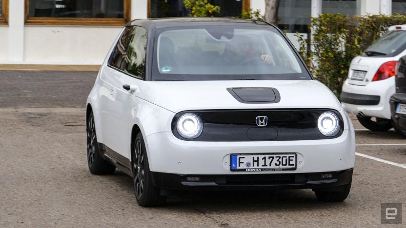 A white compact vehicle with a black roof in the parking lot.