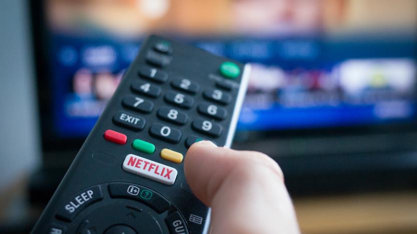 Southampton, England - July 31, 2017: Using a television remote control with dedicated Netflix button, TV in the background.