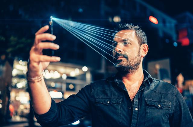 Man using mobile phone for facial recognition.