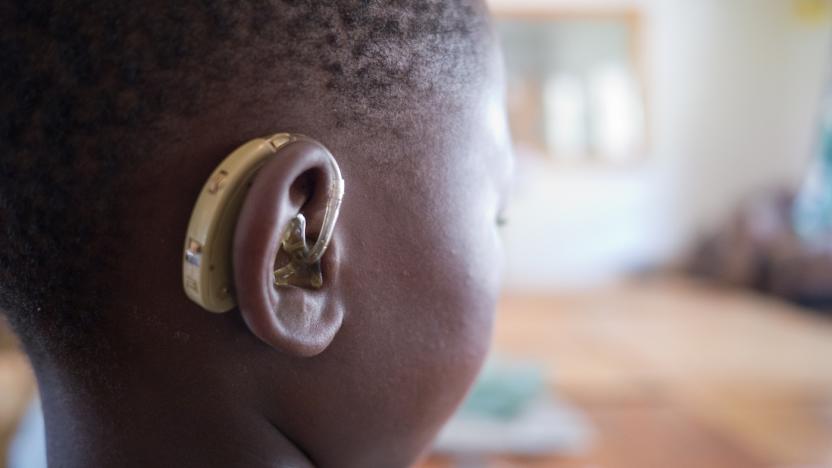 A hearing impaired boy with a solar-powered device.