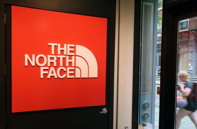 In this Monday, Aug. 13, 2018, a person walks by The North Face store in New York. (AP Photo/Ted Shaffrey)