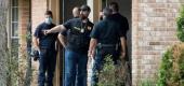 Police and first responders outside a home in Houston where officials say more than 90 people were found 'huddled together' in a possible case of human smuggling. (Houston Chronicle)