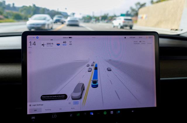 FILE PHOTO: A Tesla Model 3 vehicle warns the driver to keep their hands on the wheel and be prepared to take over at anytime while driving using FSD (Full Self-Driving) in Encinitas, California, U.S., October 18, 2023.     REUTERS/Mike Blake/File Photo