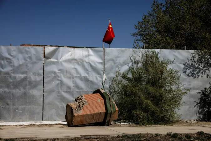 A broken-off minaret of Xinqu Mosque lies near a Chinese national flag near the house of worship in Changji outside Urumqi, Xinjiang Uyghur Autonomous Region, China, May 6, 2021. Picture taken May 6, 2021. REUTERS/Thomas Peter  SEARCH