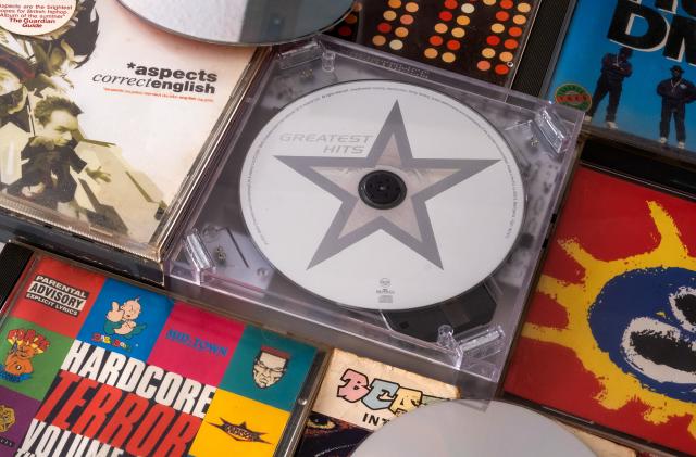 Several CD albums are pictured around a small portable CD player.