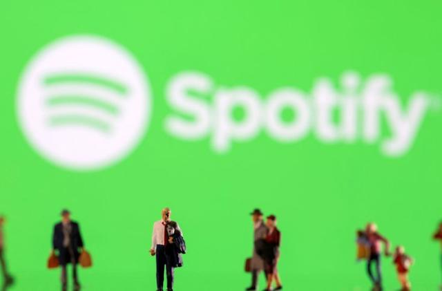 FILE PHOTO: Illustration shows small figurines and displayed Spotify logo