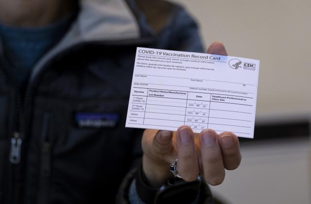 Sarah Gonzalez of New York, a Nurse Practitioner, displays a COVID-19 vaccine card at a New York Health and Hospitals vaccine clinic in the Brooklyn borough of New York Sunday, Jan. 10, 2021. The clinic, serving 30 people getting vaccines Sunday, will expand to a twenty four hour, seven days a week operation starting Monday. (AP Photo/Craig Ruttle)