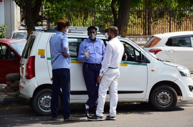 DELHI, INDIA - 2020/05/19: Cab drivers (ola,Uber) chatting on the road side while wearing face masks as a precaution, during the eased lockdown restrictions.
As a preventive measure against the spread of the COVID-19, restrictions were imposed, the govt has eased some of the restrictions after several days of lockdown. (Photo by Manish Rajput/SOPA Images/LightRocket via Getty Images)