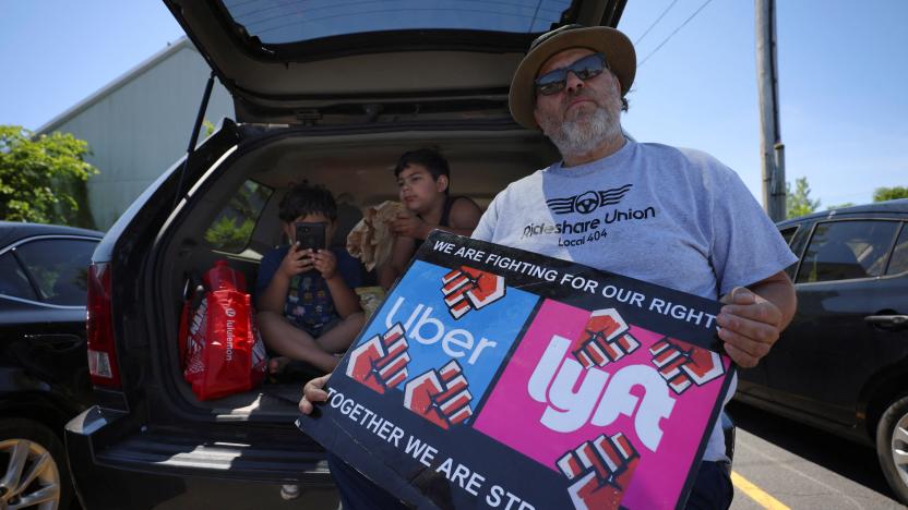 App driver Felipe Martinez and his sons Anthony and Felipe, attend a protest against Uber's elimination of fuel surcharges for drivers amid high gas prices, in Saugus, Massachusetts, U.S. June 14, 2022. REUTERS/Brian Snyder