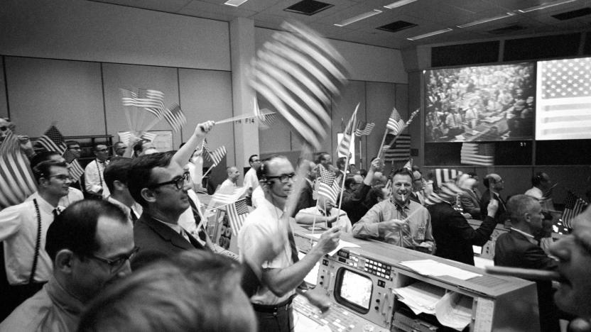 In this July 24, 1969 photo made available by NASA, flight controllers at the Mission Operations Control Room in the Mission Control Center at the Manned Spacecraft Center in Houston, celebrate the successful conclusion of the Apollo 11 lunar landing mission. (NASA via AP)