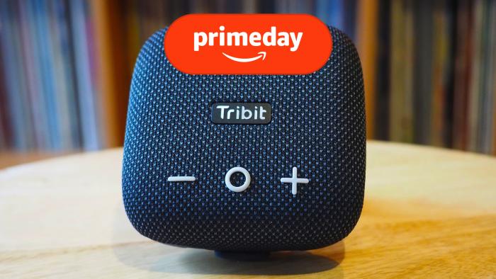 The Tribit speaker is atop a wooden table. the prime day logo is overlayed atop the image. 