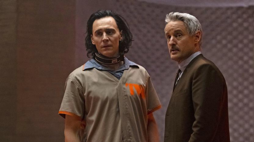 Media image from Disney+ series “Loki” featuring Tom Hiddleston (left, wearing a jumpsuit) and Owen Wilson (wearing a suit) in front of a room with soundproof walls.