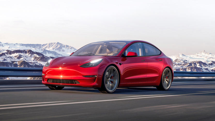 Marketing image for the Tesla Model 3. The red car drives on an open highway with snowy mountains in the background.