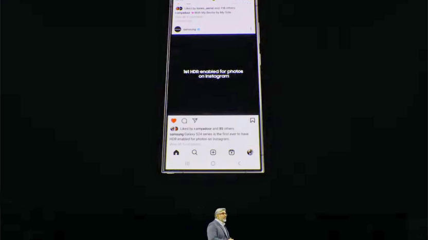 A Samsung Galaxy S24 displays an Instagram feed entry stating it's the "...first HDR enabled for photos on Instagram" on a large screen above a presenter's head at Samsung's Unpacked 2024 event.