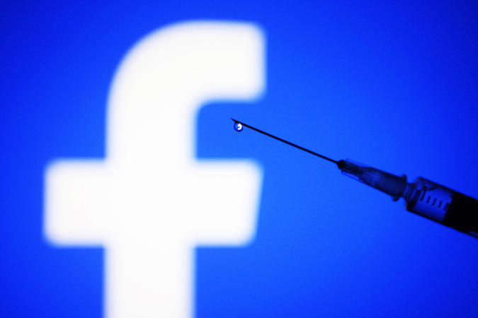 UKRAINE - 2022/02/05: In this photo illustration, a Facebook logo is seen on a smartphone screen and a medical syringe in front of it. (Photo Illustration by Pavlo Gonchar/SOPA Images/LightRocket via Getty Images)