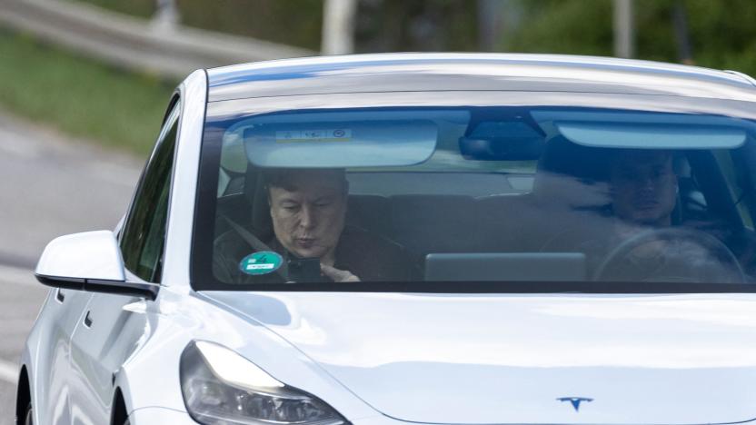 Tesla CEO Elon Musk (L) is seen as he uses his mobile device in the car arriving to the construction site for the new plant, the so-called "Giga Factory", of US electric carmaker Tesla, in Gruenheide near Berlin, northeastern Germany. - The site still has only provisional construction permits, but Tesla has been authorised by local officials to begin work at its own risk. Tesla is aiming to produce 500,000 electric vehicles a year at the plant, which will also be home to "the largest battery factory in the world", according to group boss Elon Musk. (Photo by Odd ANDERSEN / AFP) (Photo by ODD ANDERSEN/AFP via Getty Images)