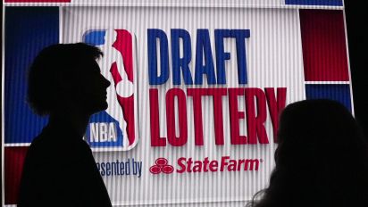 Associated Press - NBA basketball draft prospect Johnny Furphy, left, looks at the draft lottery order in front of a draft lottery sign before the draft lottery in Chicago, Sunday, May 12, 2024. (AP Photo/Nam Y. Huh)