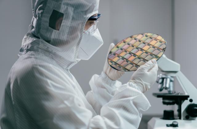 Female engineer inspecting wafer chip in laboratory