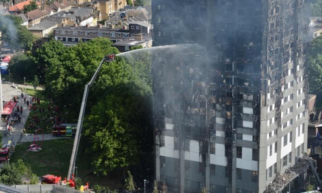 Firefighters spray water on the fire raging in the Grenfell Tower.