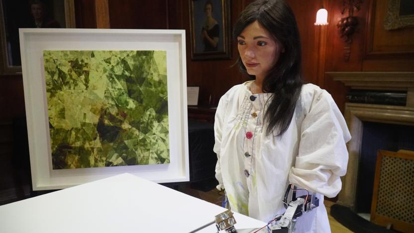 Robot artist 'Ai-Da' sketches using a pencil attached to her robotic arm, while standing next to a painting based on her computer vision data when run through algorithms developed by computer scientists in Oxford, Britain June 4, 2019. Picture taken June 4, 2019. REUTERS/Matthew Stock