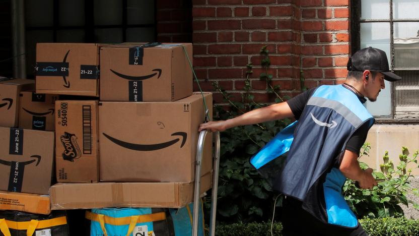 An Amazon delivery worker pulls a delivery cart full of packages during its annual Prime Day promotion in New York City, U.S., June 21, 2021.  REUTERS/Brendan McDermid