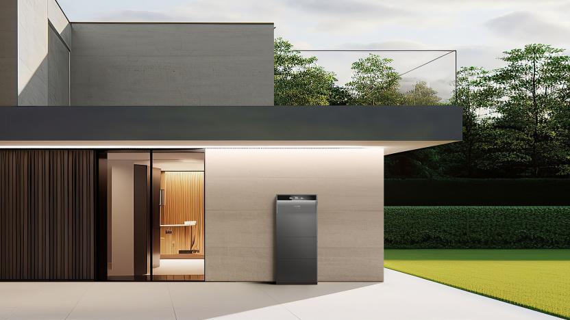 Anker's new Solix home energy storage with modular solar battery system is displayed outside of a modern home, appearing as a slim grey appliance against an outer wall (protected by an overhanging roof).