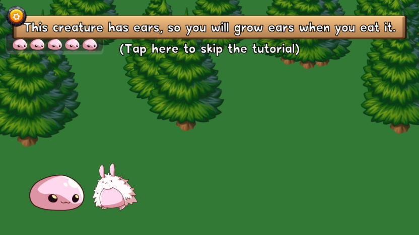 A screenshot from the game "You Are What You Eat" featuring some trees, two pink creatures on the bottom left and the words "This creature has ears, so you will grow ears when you eat it" at the top. 