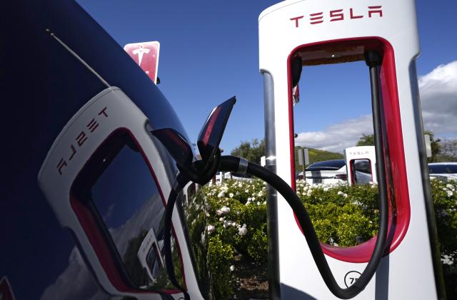 FILE - A Tesla auto charges on May 10, 2023, in Westlake, Calif. All of Ford Motor Co.'s current and future electric vehicles will have access to about 12,000 Tesla Supercharger stations starting in 2024, according to an announcement Thursday, May 25, 2023, by Ford CEO Jim Farley and Tesla CEO Elon Musk. (AP Photo/Mark J. Terrill, File)