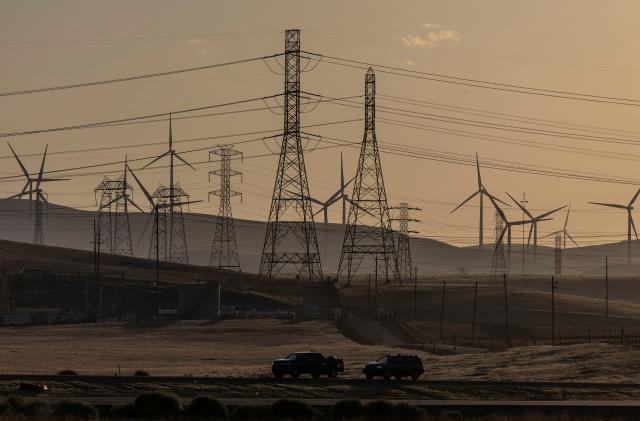 A view of windmills and power lines, as California's grid operator urged the state's 40 million people to ratchet down the use of electricity in homes and businesses as a wave of extreme heat settled over much of the state, near Tracy, California, U.S., August 17, 2022. REUTERS/Carlos Barria