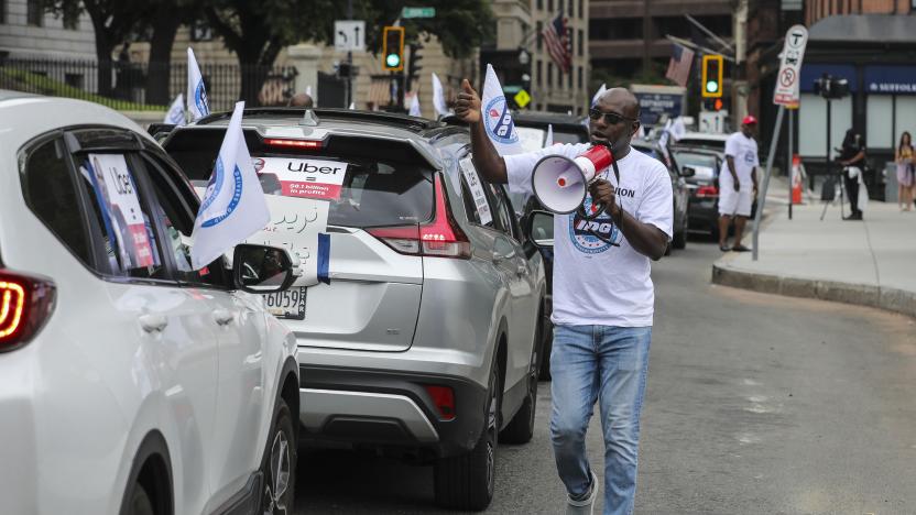 Boston, MA - August 17: Aziz Bah, who works as an Uber driver, encourages drivers to get out of their cars while parked in front of the State House during a demonstration on Wednesday. Gig drivers caravanned from Allston to the State House to demand legislative action to improve their jobs and unionize. (Photo by Erin Clark/The Boston Globe via Getty Images)