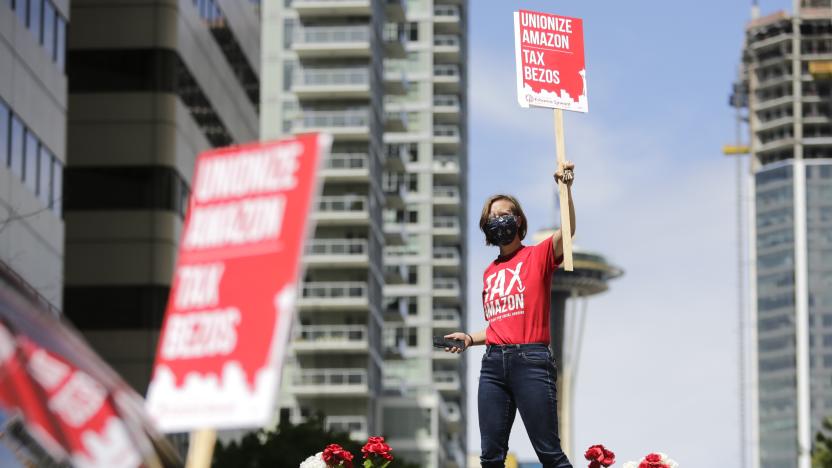 TOPSHOT - Protesters stand on their cars and block traffic as they participate in a "car caravan" protest at the Amazon Spheres to demand the Seattle City Council tax the city's largest businesses in Seattle, Washington on May 1, 2020. - U.S. employees of Amazon, its supermarket subsidiary Whole Foods and supermarket delivery services were called to strike on May 1, taking advantage of May 1 to denounce employers accused of not sufficiently protecting them in the face of the pandemic. (Photo by Jason Redmond / AFP) (Photo by JASON REDMOND/AFP via Getty Images)