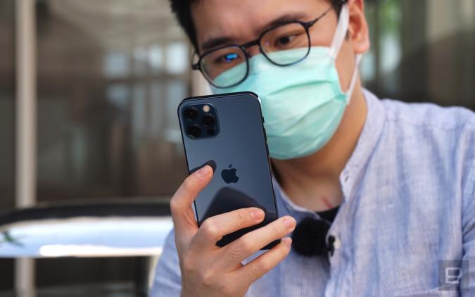 An iPhone 13 Pro user wearing a surgical mask.